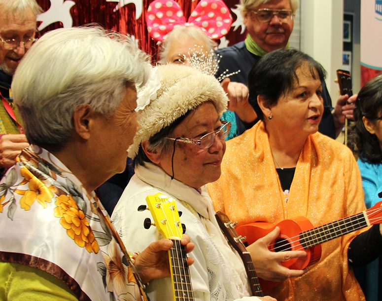 Seniors at SRCHC playing music with ukeleles and singing during the 40 year anniversary event