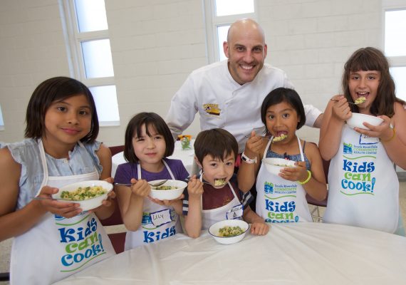 Chef Afrim with children ages 8 to 10 in the Kids Can Cook program.